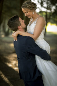 Steven Perdikis Photography wedding photograph of a bride being held by a groom. She is smiling while looking into his eyes