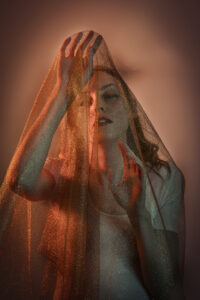 Fine art photograph of a woman pawing at a golden veil. Steven Perdikis Photography