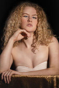 A format portrait of a woman with blonde curly hair